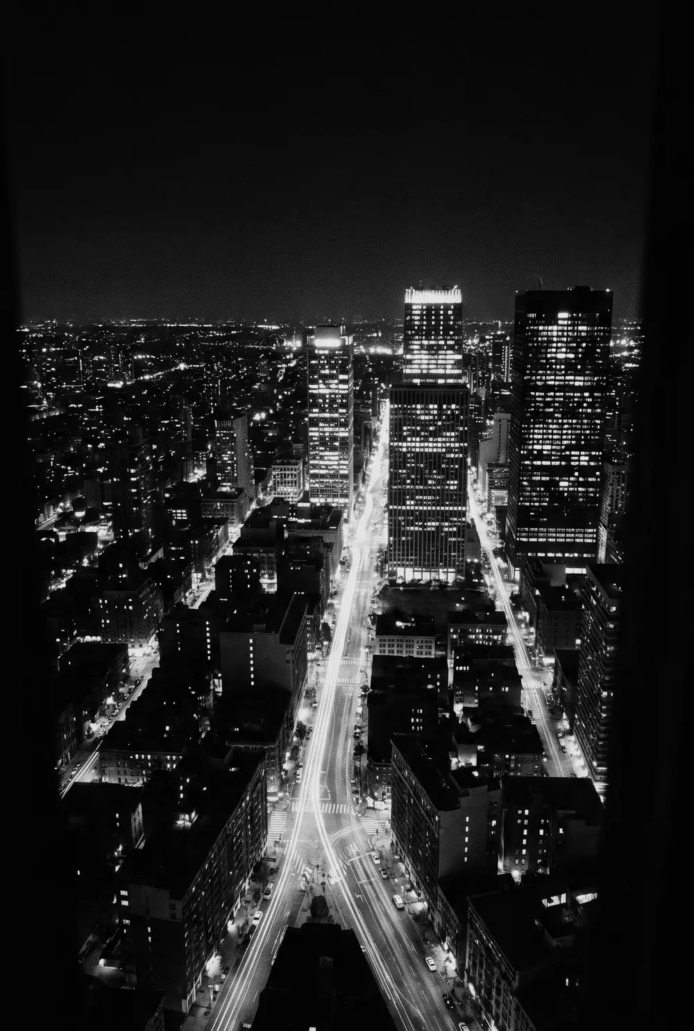 A city grid at night seen from above, streets traced in light